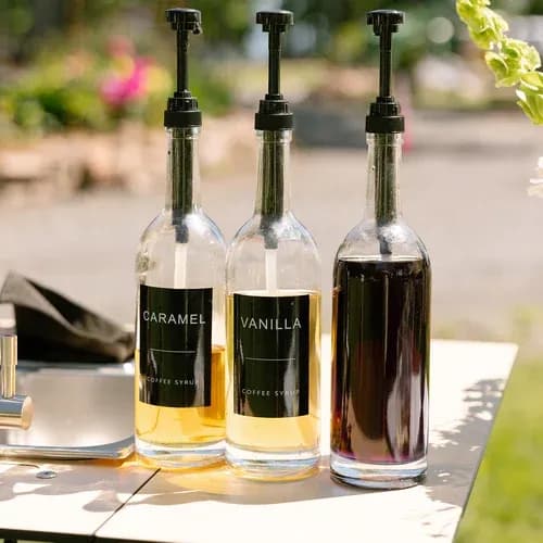 Bottles of house syrups lined up on a Zerno espresso bar.