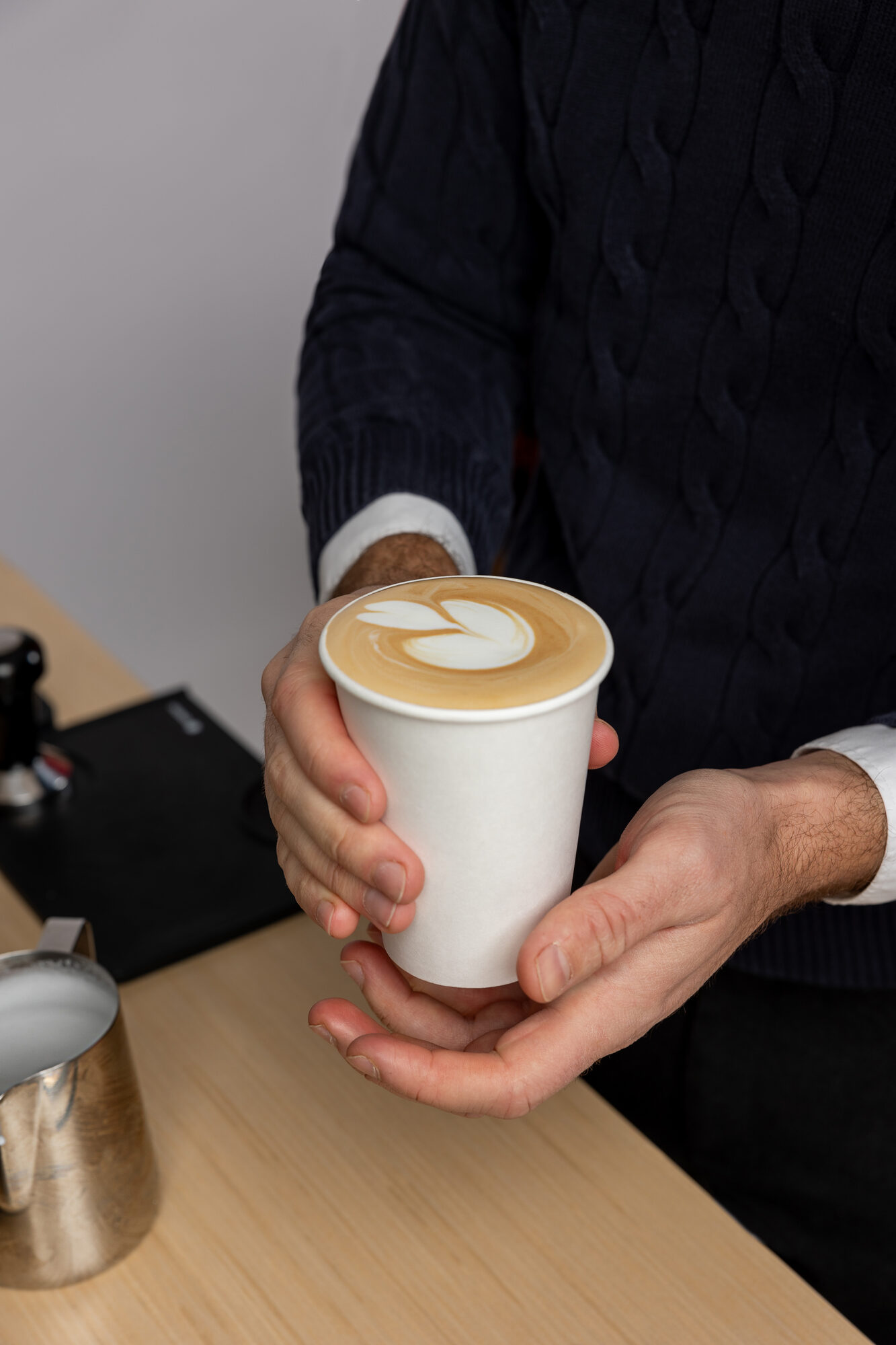 Guest holding a fresh latte with latte art from the Zerno cart