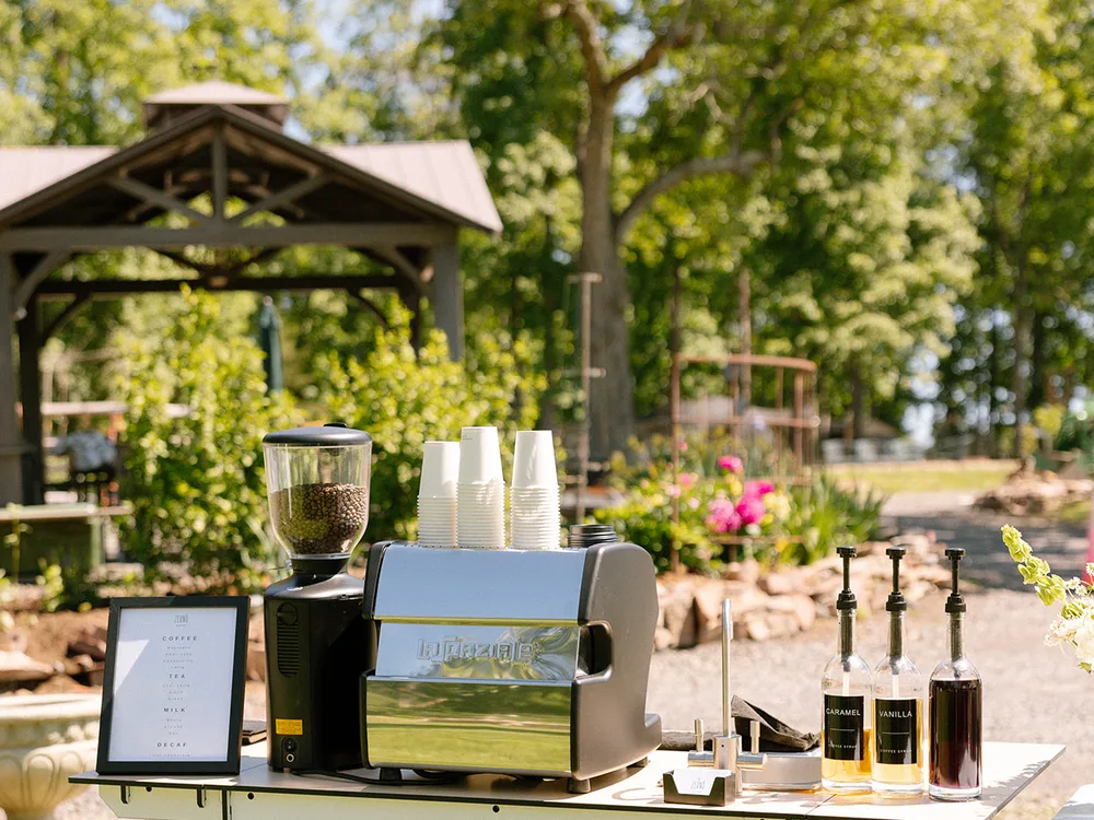 Zerno espresso machine and syrup bottles set up at a private garden event
